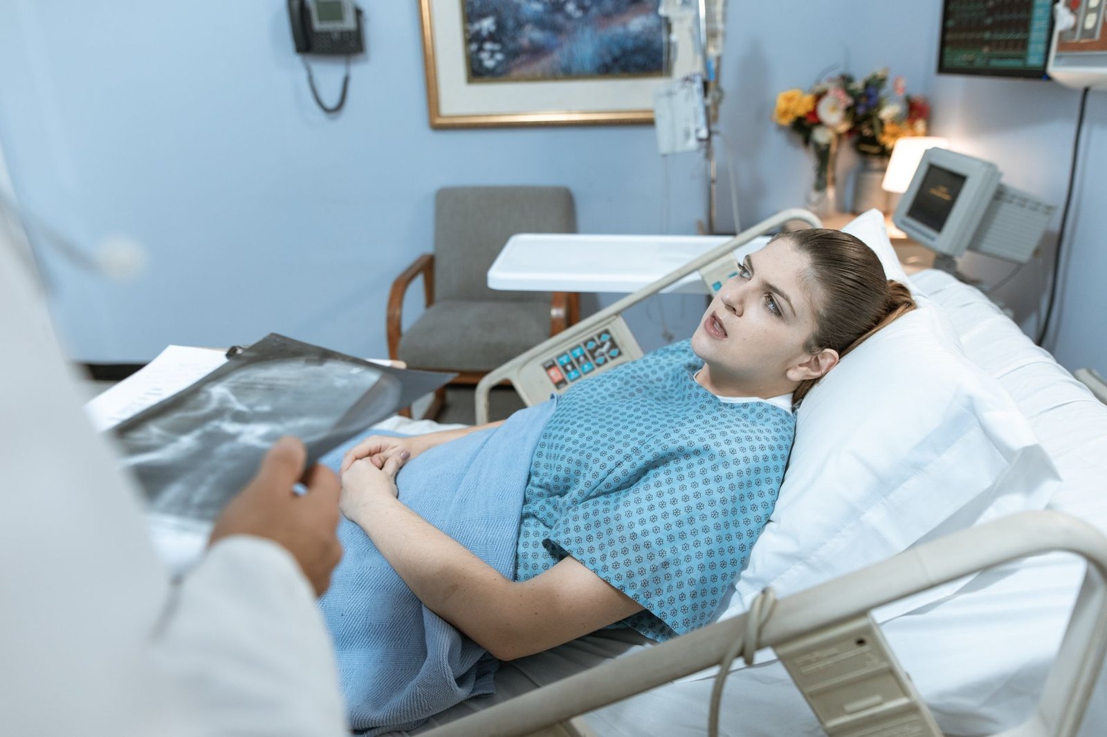 Caucasian woman in hospital bed receiving care from healthcare professional. — Cutting-Edge Treatments for Cardiovascular Con