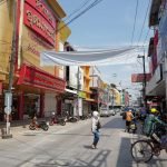 Lively urban street in Thailand with people, shops, and traffic under a sunny sky. — Exploring the Best Bicycles to Own in Ta