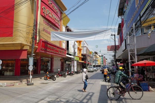 Lively urban street in Thailand with people, shops, and traffic under a sunny sky. — Exploring the Best Bicycles to Own in Ta