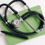 Top view of a stethoscope and pen on a green notepad, ideal for medical and educational themes. — Indulge in Blissful Relaxat