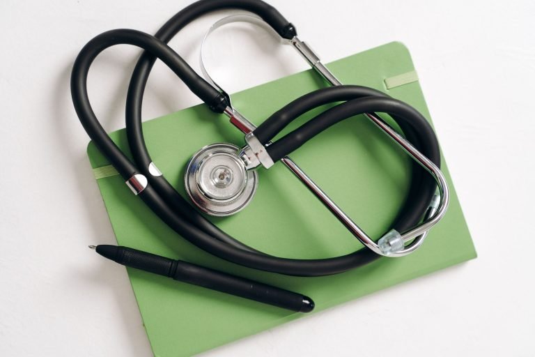 Top view of a stethoscope and pen on a green notepad, ideal for medical and educational themes. — Indulge in Blissful Relaxat