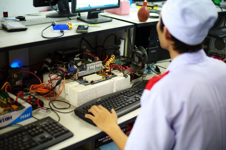 A technician in uniform working on a motherboard at a desk in a laboratory setting. — MetaTrader 4 WebTrader: Trade Directly