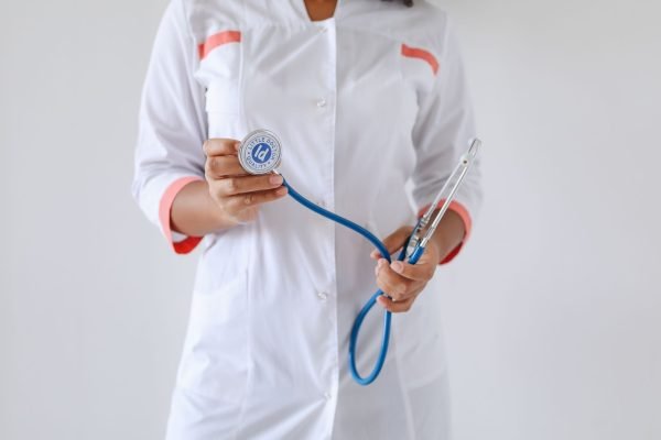 Close-up of a female doctor holding a blue stethoscope, emphasizing healthcare and professionalism. — Revitalize Your Vitalit