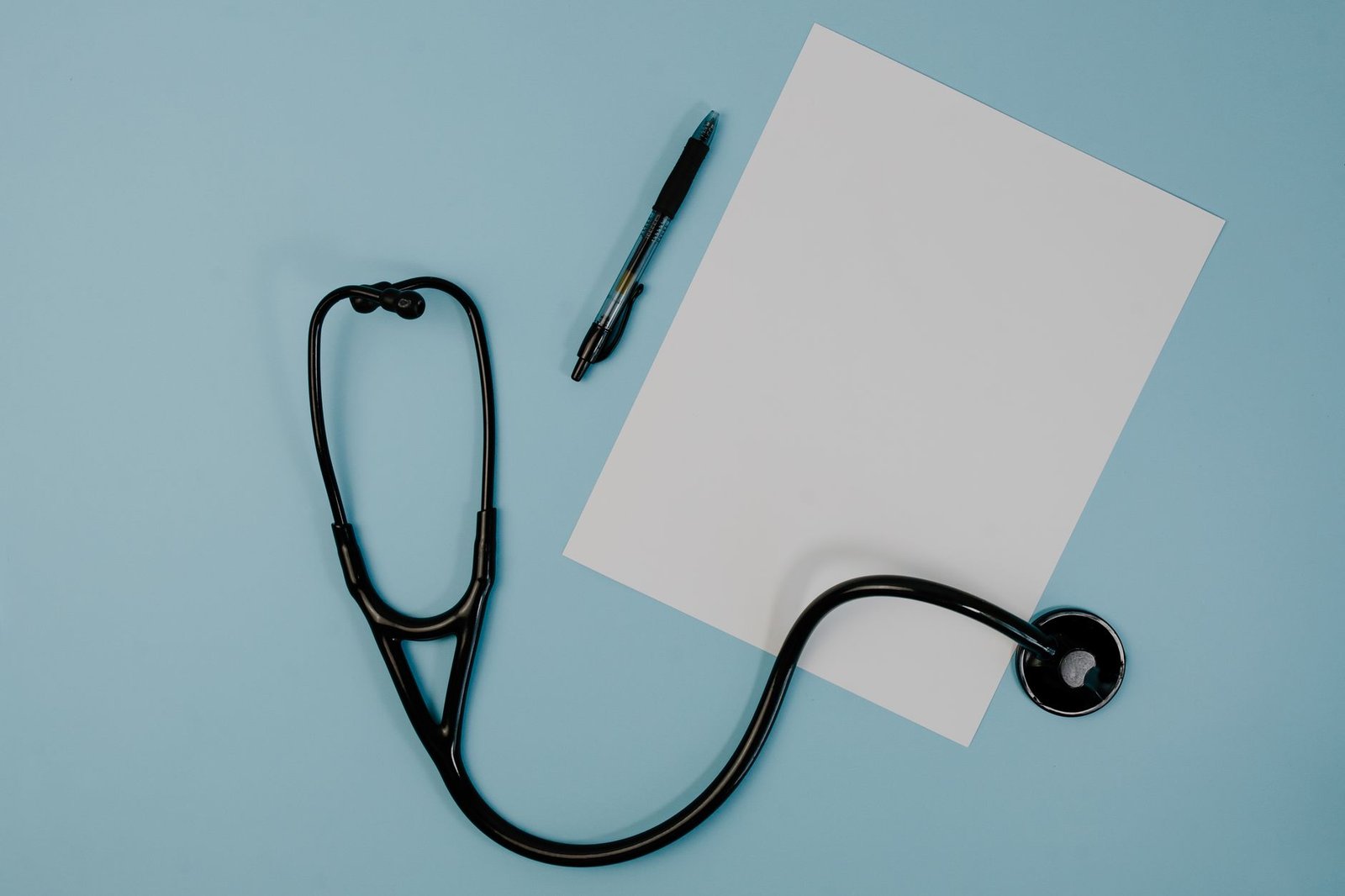 Flat lay of stethoscope, blank paper, and pen on blue surface — Understanding Testosterone Therapy: A Comprehensive Guide